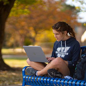 Student sitting on bench on campus
