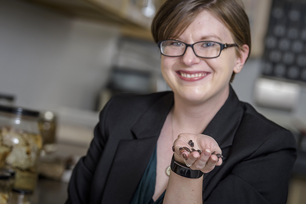 Rebecca Schmidt-Jeffris on campus with a handful of mealworms