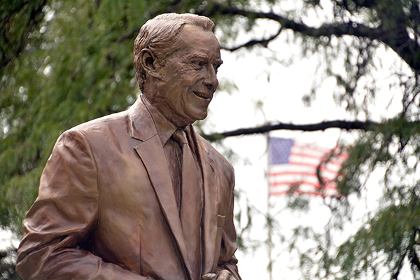 Statue of Bob Dole with a US flag in the background