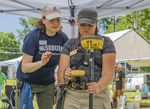 Shelby Beltz, ba ’18 (right), takes measurements while Laura Murphy, associate professor, archaeology, assists