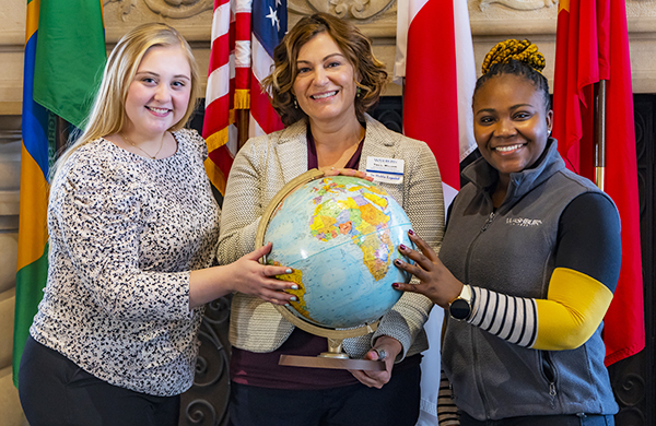 International Programs participants holding a globe