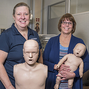 Nursing faculty pose with PEARS training equipment