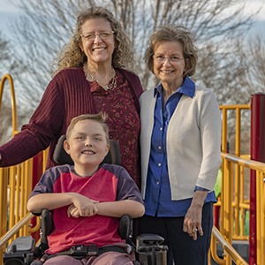 Jeannette Wood, her son and her teacher, Shirley Waugh pose at a playground