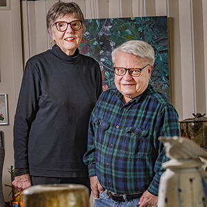 David Peters and Barbara Waterman-Peters posing in their home surrounded by art