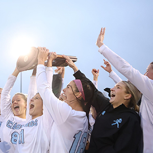 The soccer team holds up a trophy during a celebration