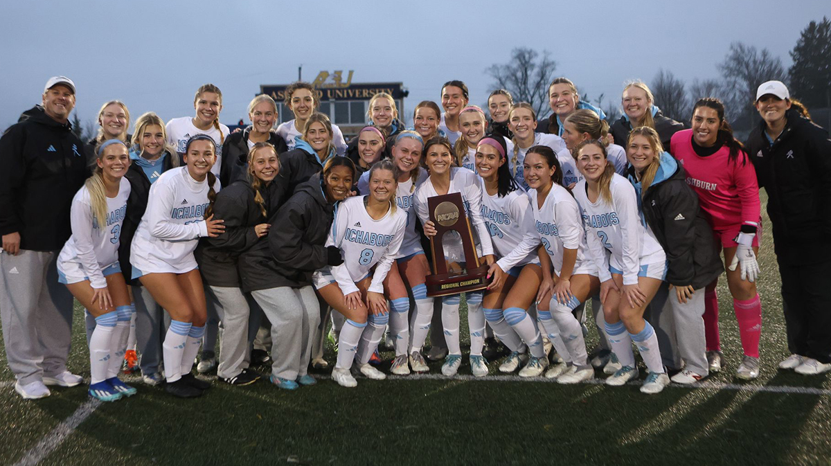 The soccer team poses with their NCAA regional championship trophy