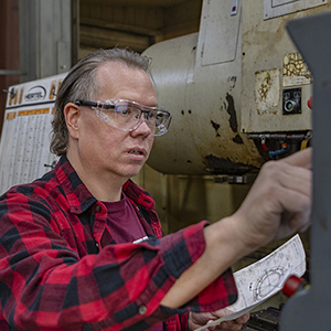 Chris Thoreson programs a computer on a mill that makes rubber mixing equipment. 