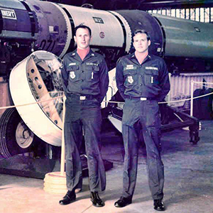 Two soldiers posing in front of missile
